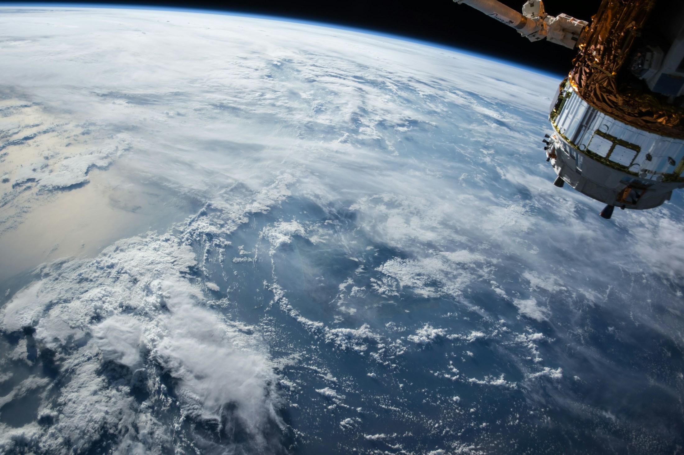 Earth seen from orbit with a spacecraft in the foreground.